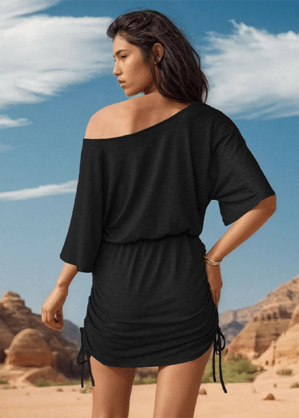 Black ruched mini dress with off-the-shoulder neckline and cinched waist on model