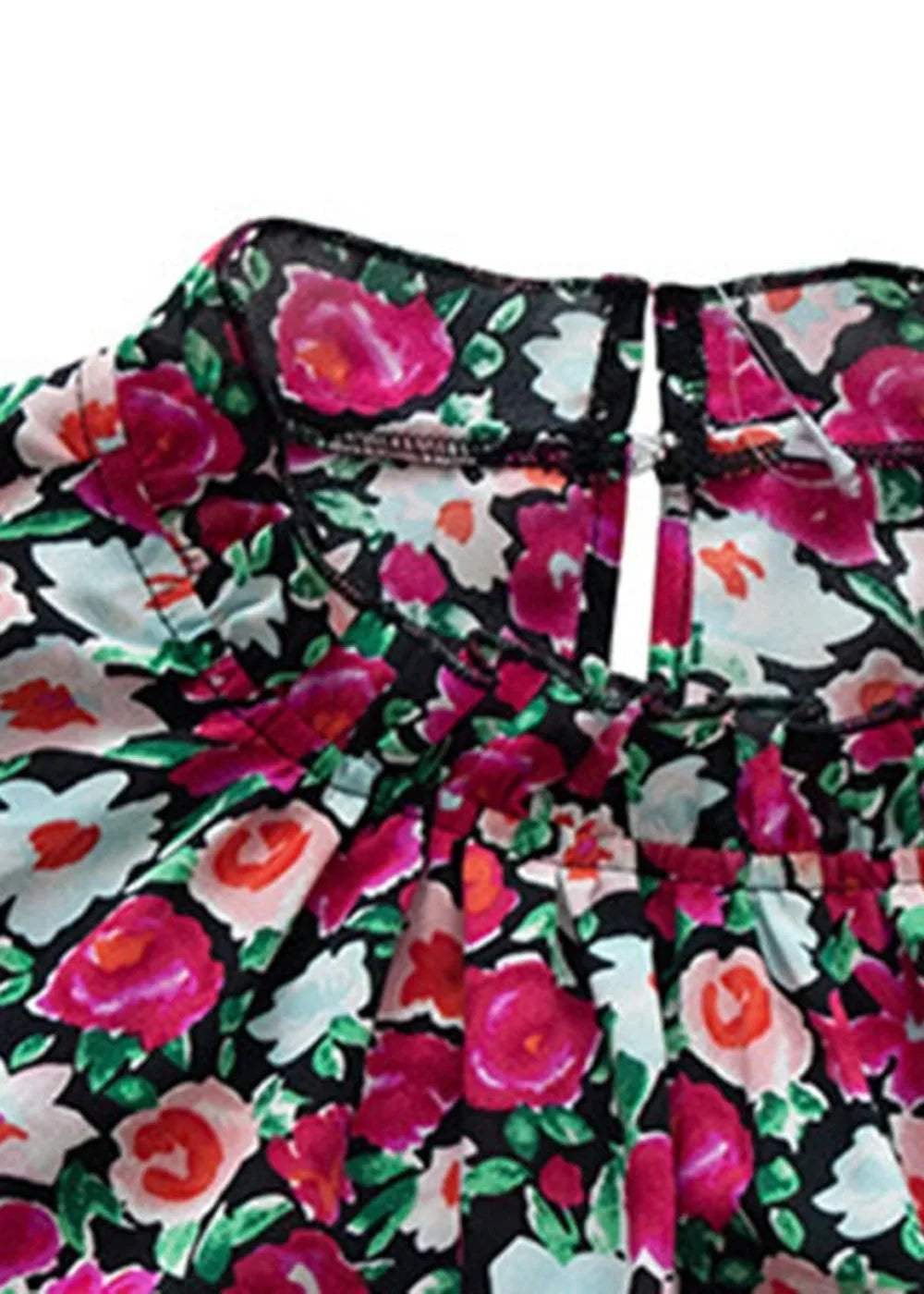 Close-up of a black top with a vibrant pink and light blue floral print and a ruffled neckline.