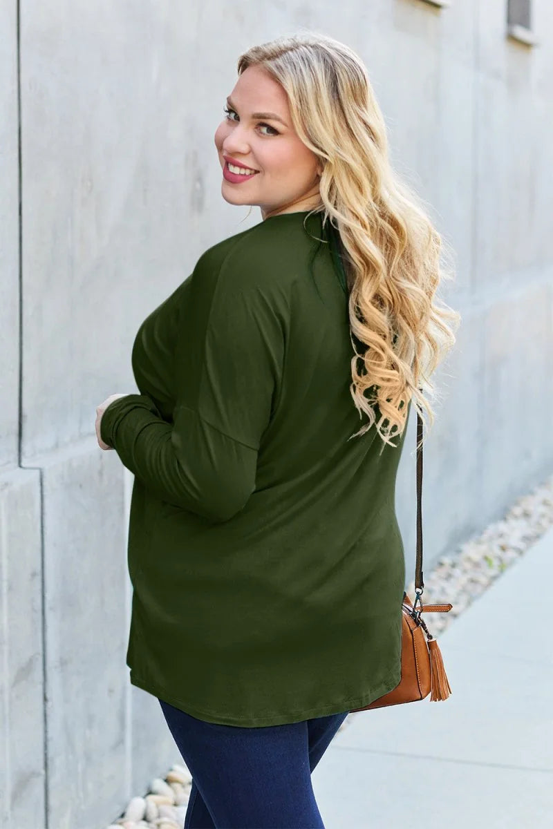 Olive green long-sleeve top with a relaxed fit, worn by a model with blonde wavy hair.
