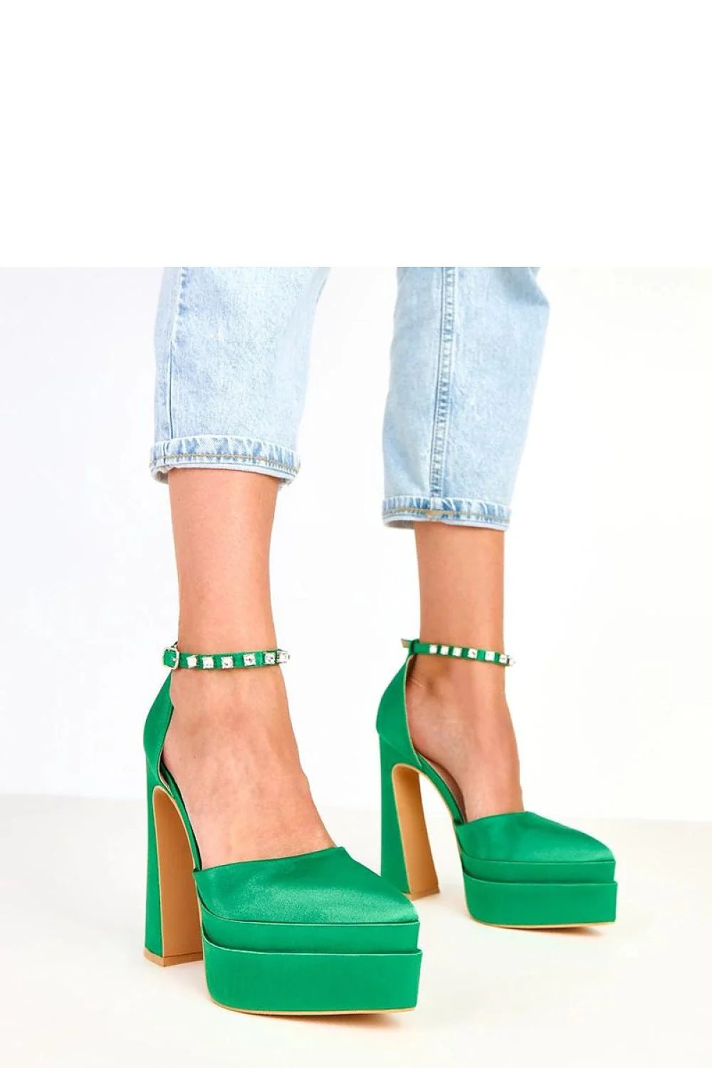 Emerald green satin platform heels with rhinestone ankle straps, worn with light wash cuffed jeans.
