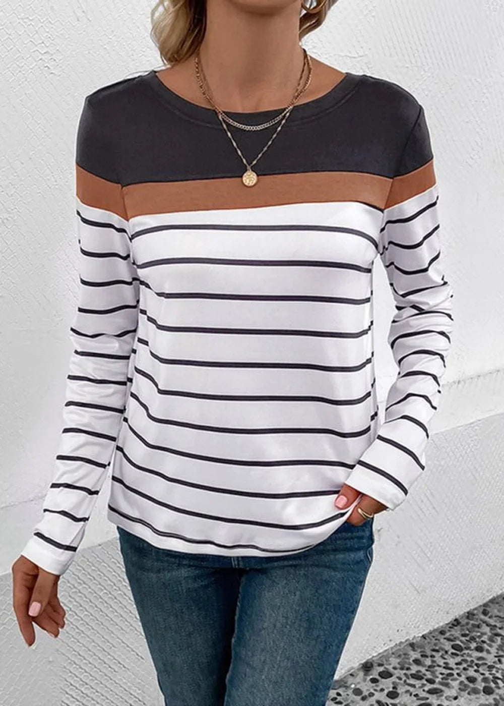 Long-sleeved striped t-shirt with brown and black colorblock detail on model.