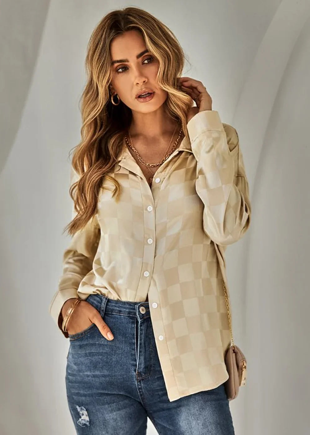 Beige plaid collared button-up shirt with gold chain necklace and blue jeans on model