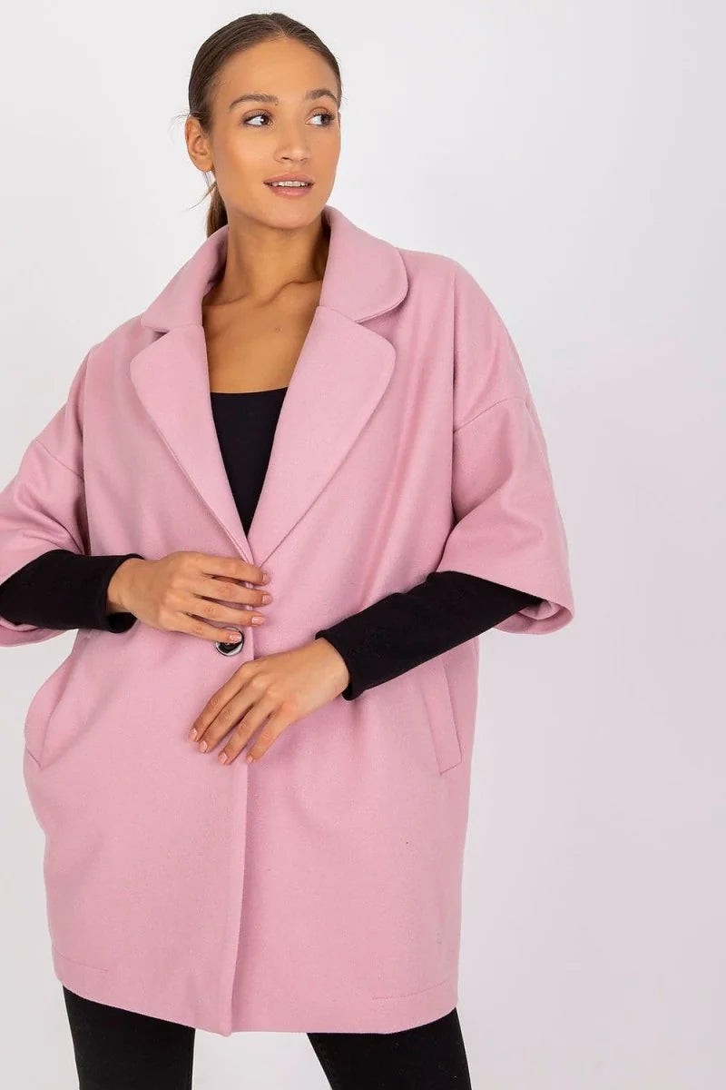 Loose-fit pink polyester jacket with a black long-sleeved top and black pants on a model.
