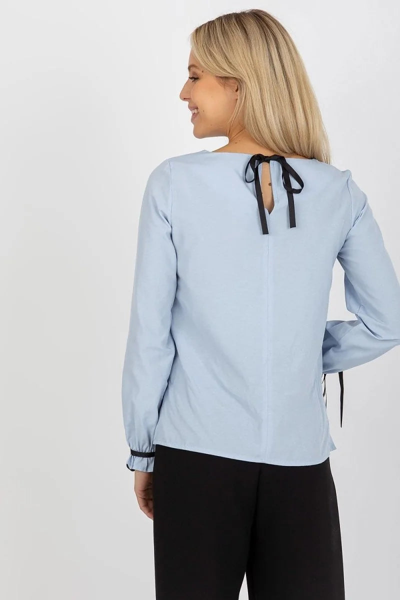 Light blue cotton long-sleeve top with black bow detail at the neckline and tie details on the cuffs.