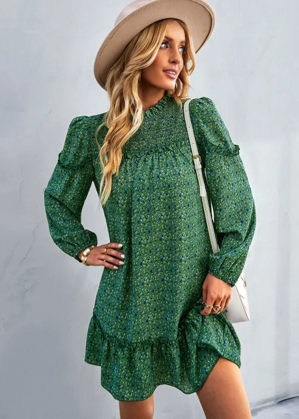 Green floral print dress with smocked neckline and ruffled hem, worn by a model with a hat.