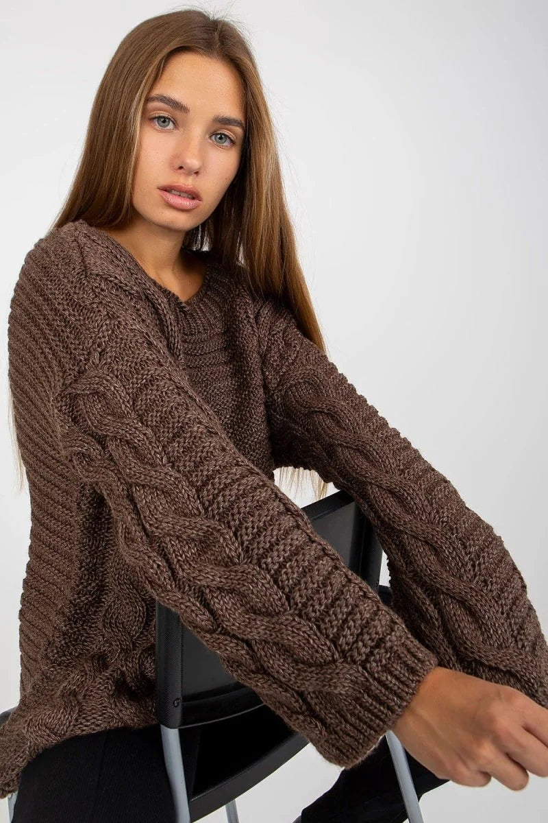 Brown acrylic and wool blend sweater with cable knit sleeves, v-neck, and extended fit on a model.