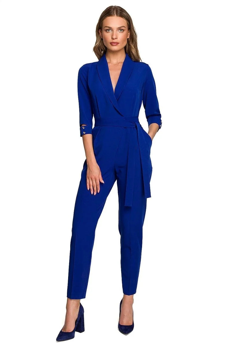 Royal blue jumpsuit with a belted waist, V-neck, and 3/4 sleeves, shown full length on a model.
