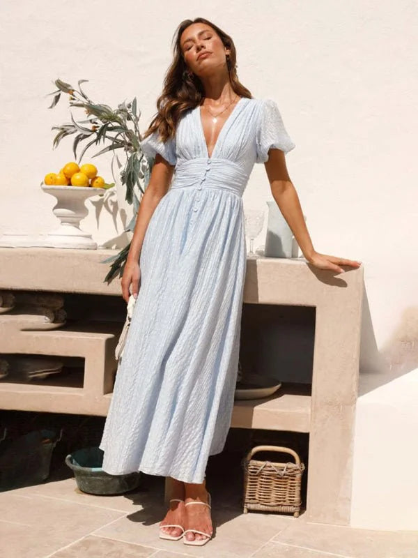 Light blue textured V-neck midi dress with puff sleeves and button details, on a model.