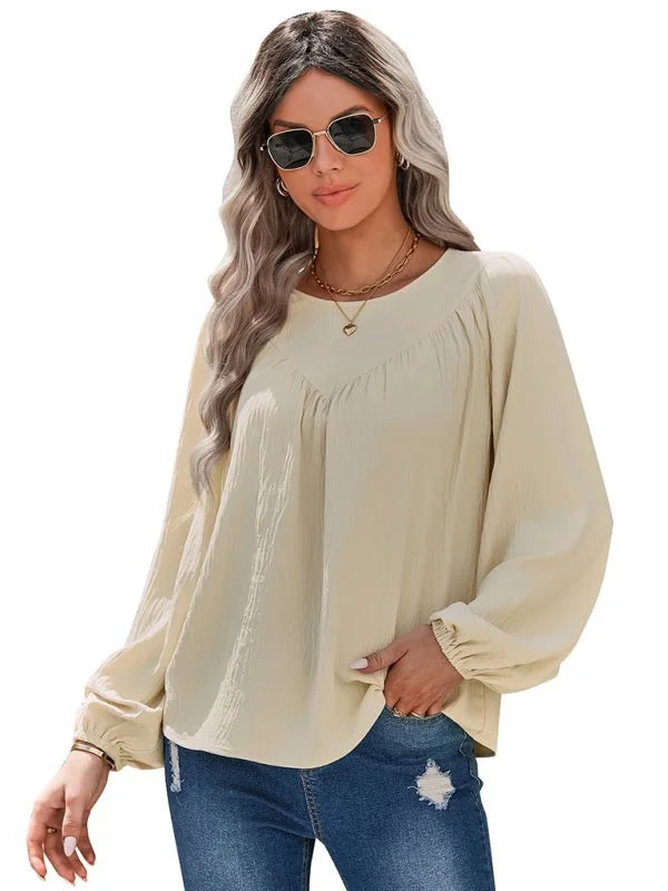 Cream textured long-sleeve peasant blouse with gathered neckline, on a model wearing distressed jeans.