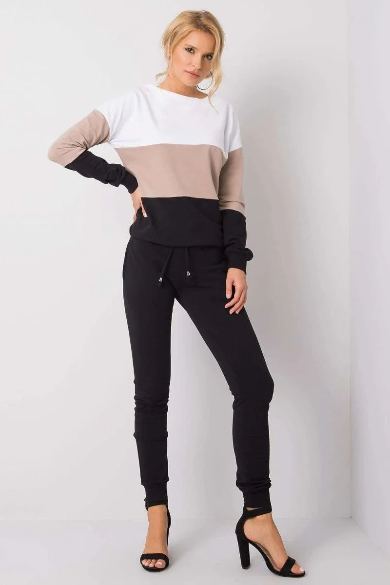 Full-length view of a woman wearing a color-blocked sweatshirt with black drawstring pants and black high-heeled sandals.