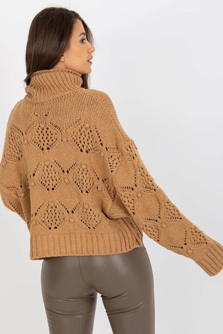 Brown knit sweater with open diamond pattern, high neck, and ribbed cuffs on model.