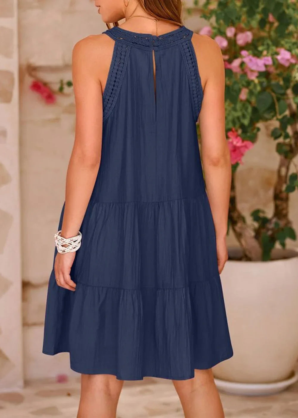 Navy blue tiered dress with crochet neckline, shown from the back on a model.