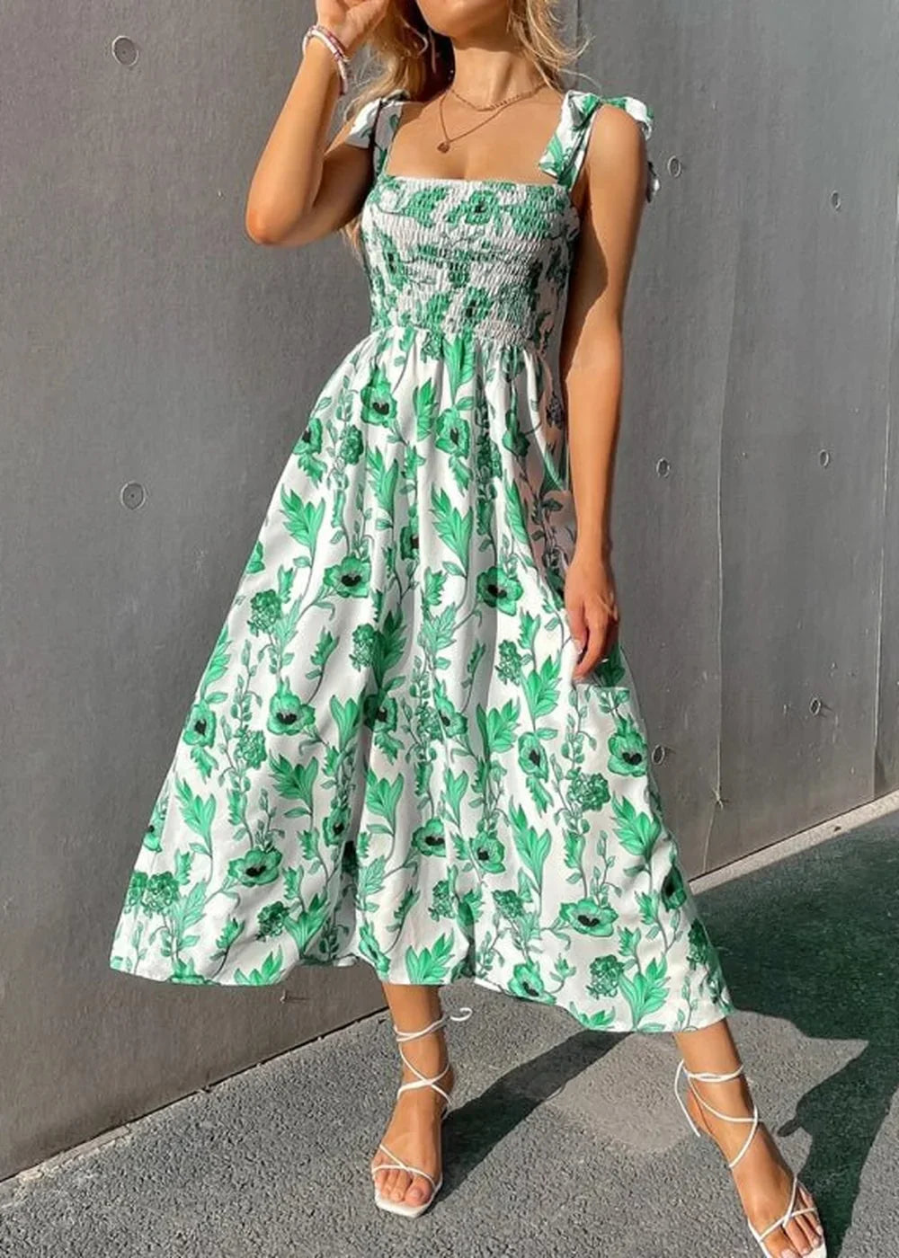 White and green floral print midi dress with square neckline and tie straps, worn by a model.