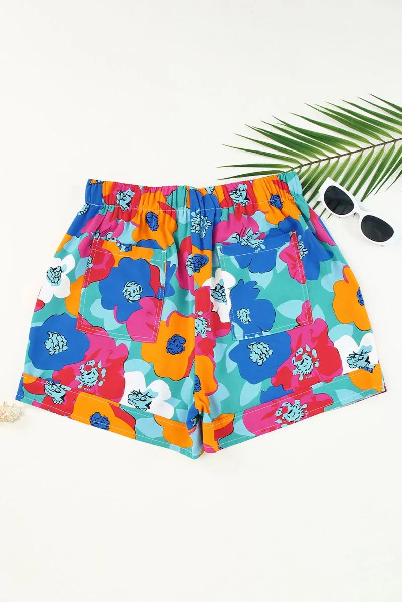 Bright floral print shorts with blue, pink, orange, and white flowers on a teal background.
