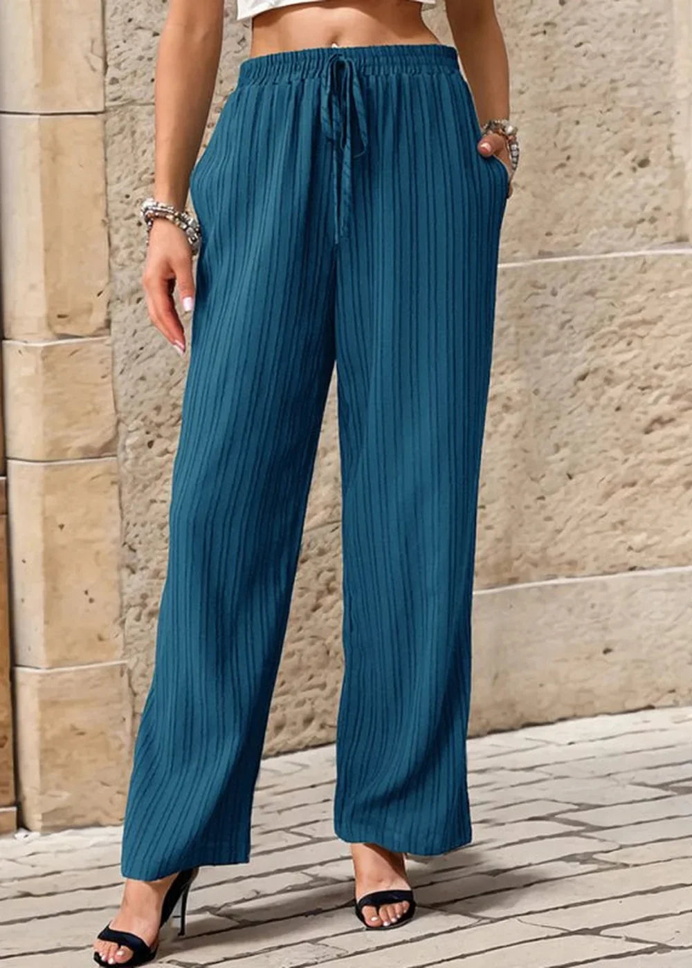 Teal textured wide-leg pants with drawstring waist, on a model showing full length.