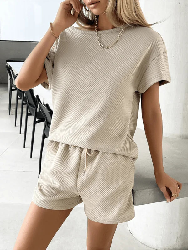 Textured beige short suit with a geometric pattern, featuring a crew neck top and drawstring shorts on a model.