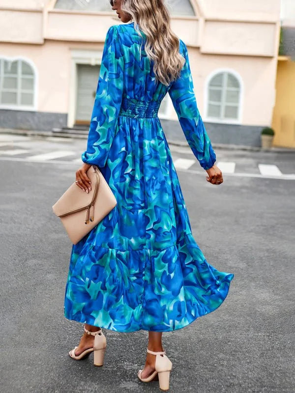 Blue and green abstract print maxi dress with smocked waist and tiered skirt.
