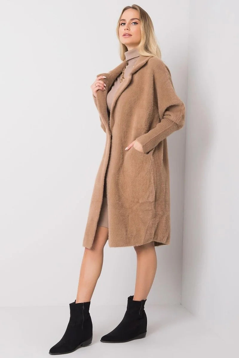 Tan fuzzy longline cardigan with shawl collar, on model wearing beige dress and black boots.