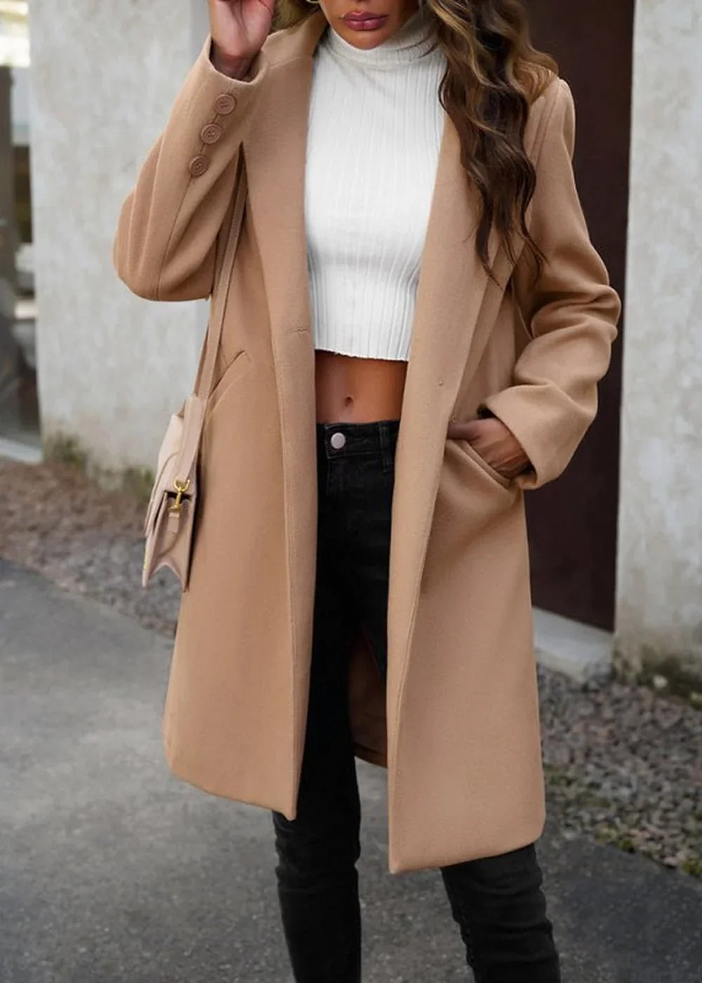 Tan wool-blend coat with a notched lapel and subtle button detail on the sleeve, worn over a white turtleneck crop top and...