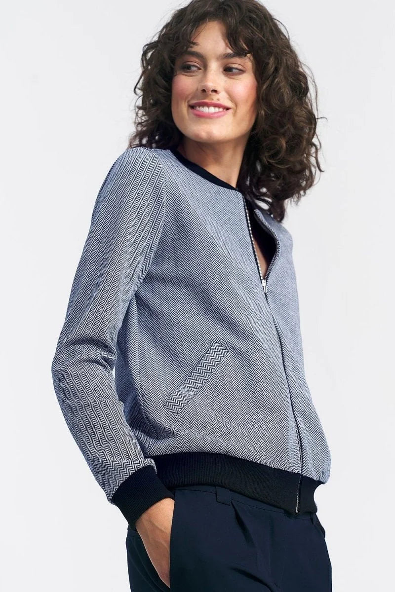Navy and white herringbone bomber jacket with black trim, worn by a model.