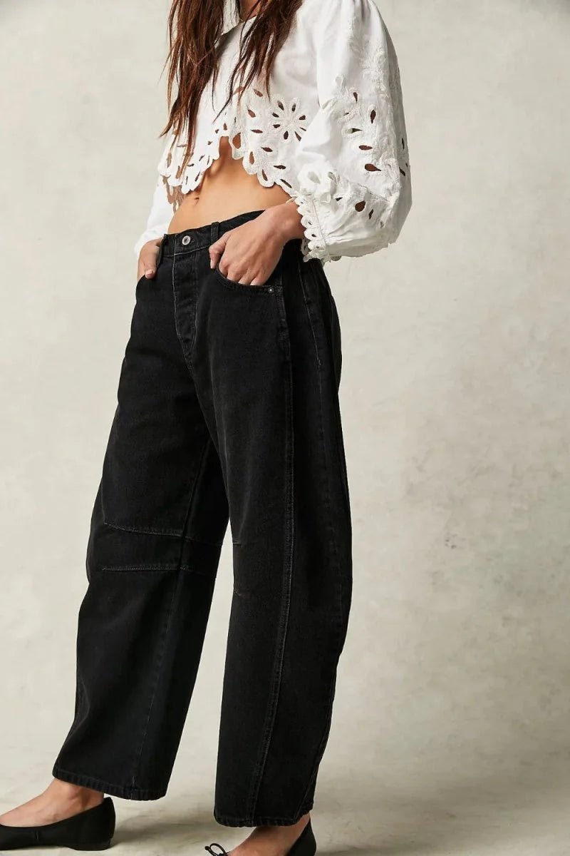 Black relaxed-fit denim jeans with a paneled design and visible stitching details.