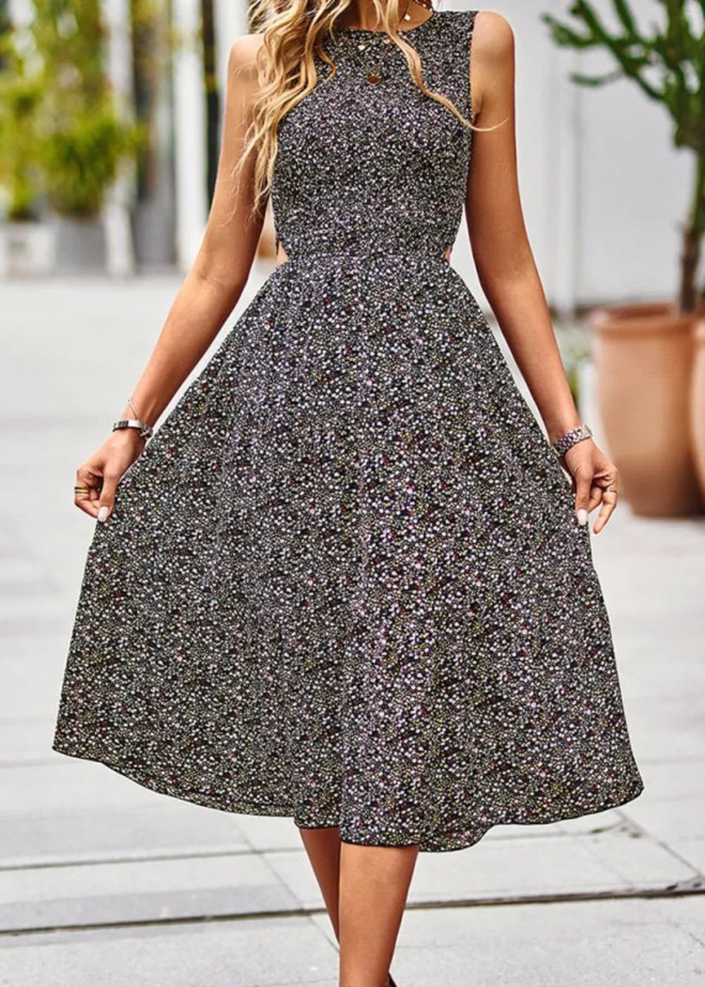 Black floral print midi dress with cutout sides and sleeveless design on a model.