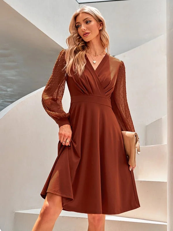 Brown A-line dress with sheer dotted sleeves and a V-neck wrap bodice.