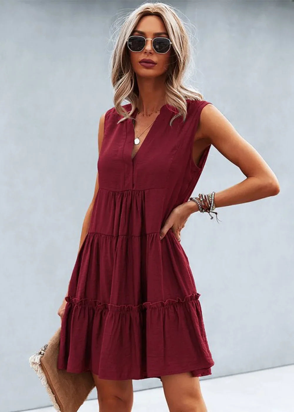 Maroon tiered ruffle dress with V-neck and necklace on model.