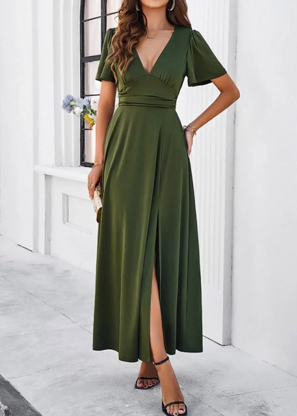 Olive green V-neck maxi dress with flutter sleeves and a thigh-high slit on model.