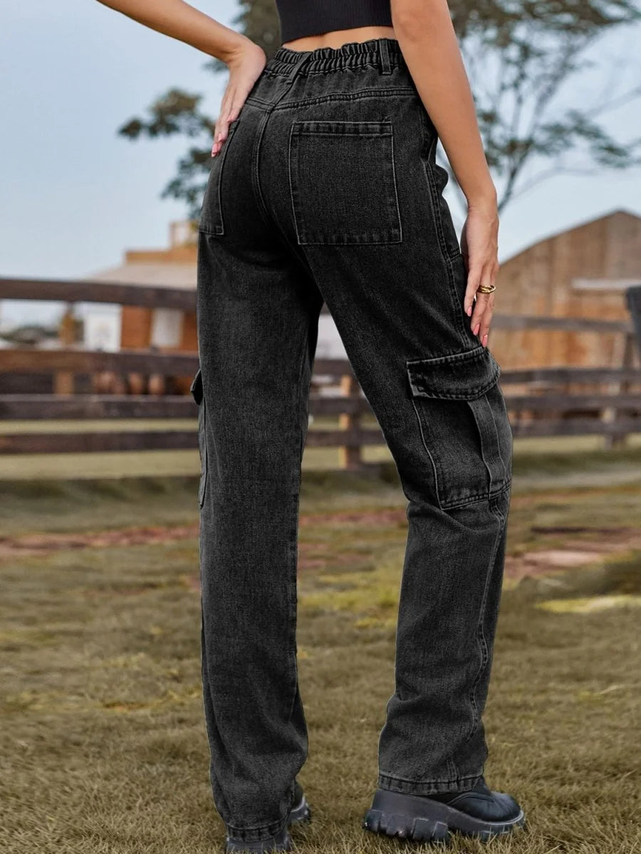 Back view of dark wash denim cargo pants with elastic waistband, patch pockets, and a relaxed fit.