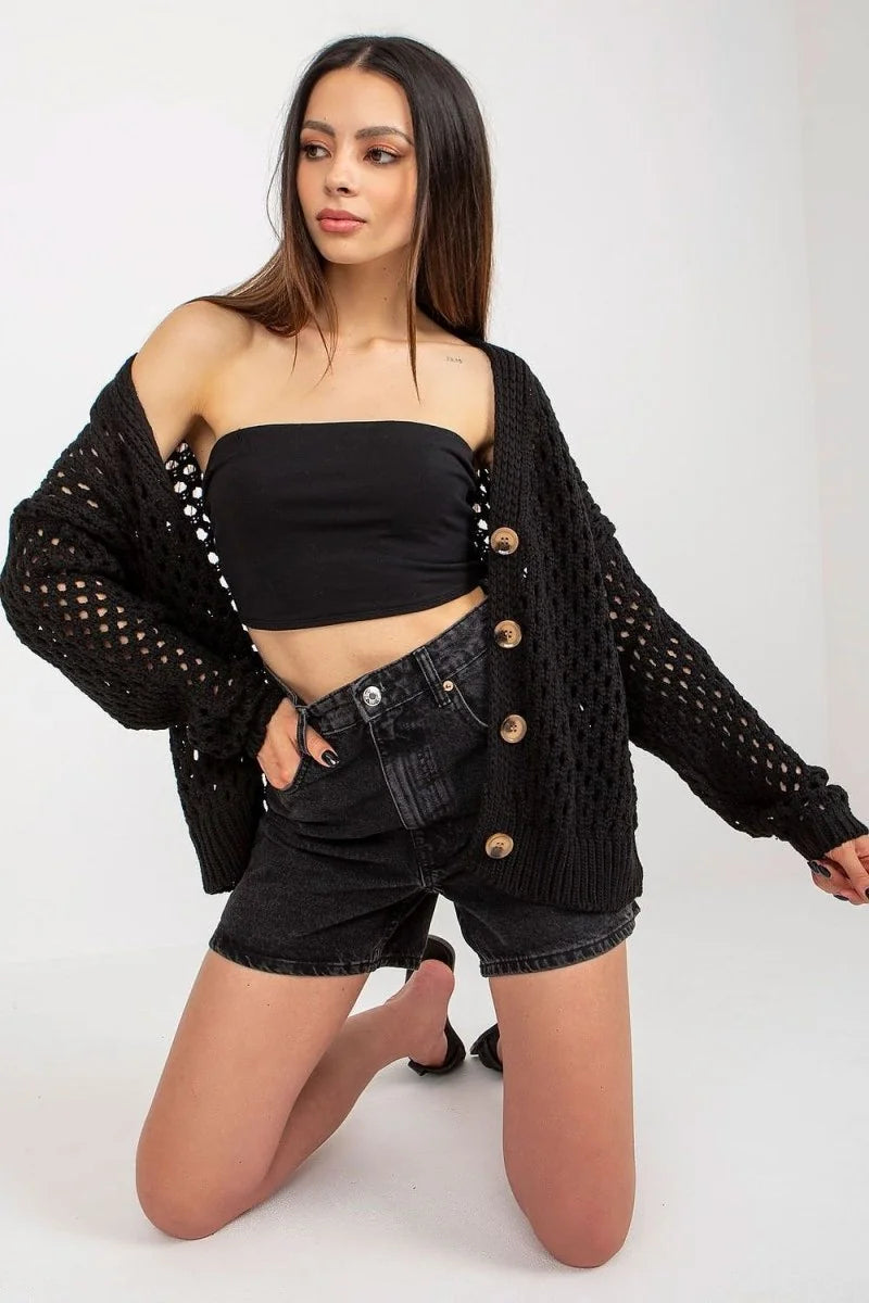 Cropped black knit cardigan with open weave detail and wooden buttons on a model.