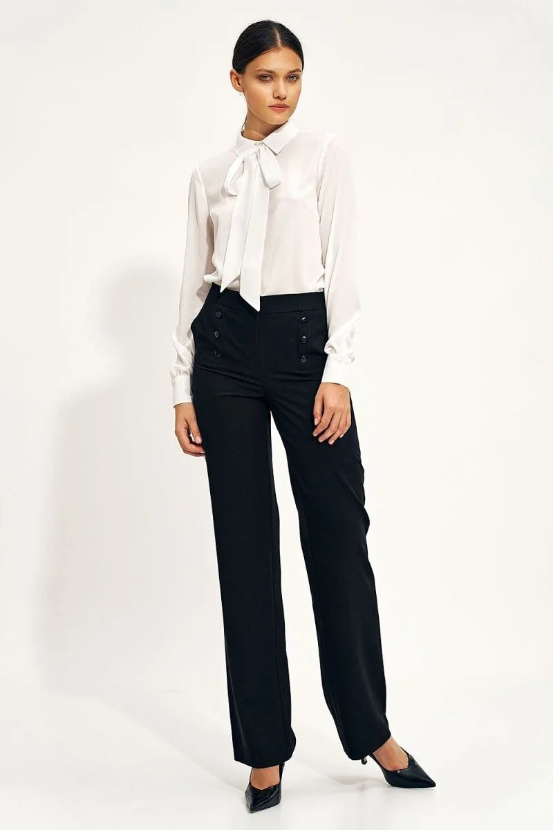 High-rise black wide-leg pants with decorative buttons at the waist, on a model.