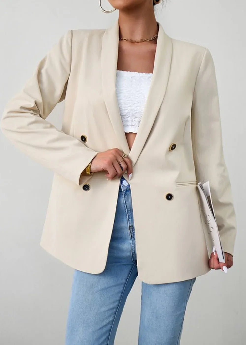 Cream double-breasted blazer with gold buttons, paired with a white lace tube top and light wash jeans.