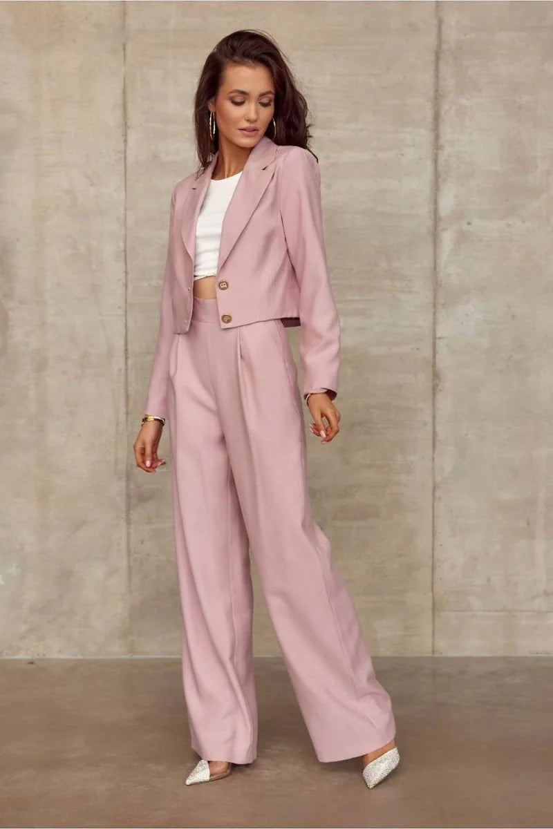 Model wears wide-leg pink trousers with a textured fabric, featuring a regular fit and pleated front.