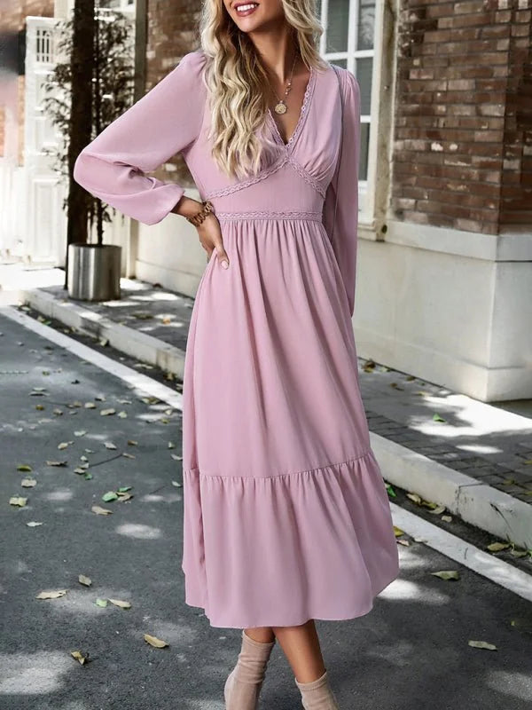 Flowy pink midi dress with lace trim and long sleeves, shown on a model.