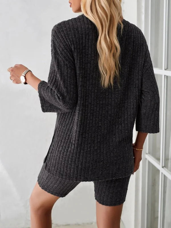 Dark grey ribbed knit lounge set with relaxed fit, showing back view of top and shorts on a model.