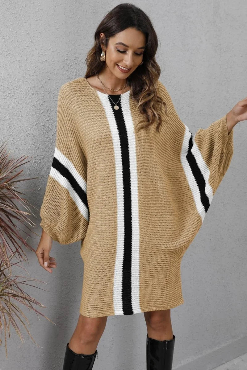 Tan acrylic knit sweater dress with black and white stripes, featuring a relaxed fit and dolman sleeves.