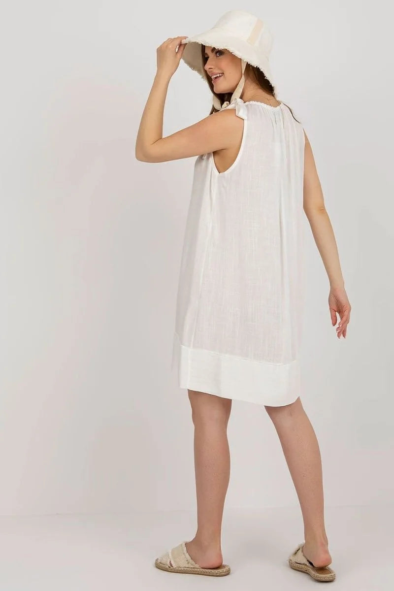 Loose white viscose day dress with tie shoulder details and frayed brim hat.