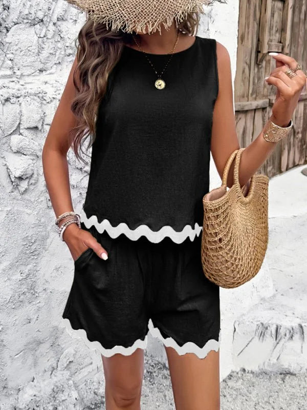Black sleeveless top and shorts set with white scalloped trim, on a woman wearing a straw hat.