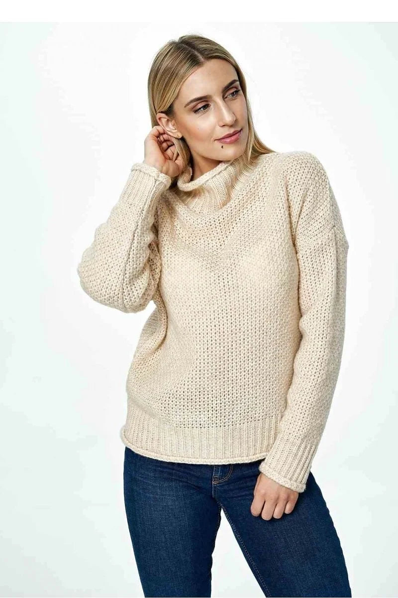 Beige knit sweater with a cowl neck and textured stitch detail on a model.