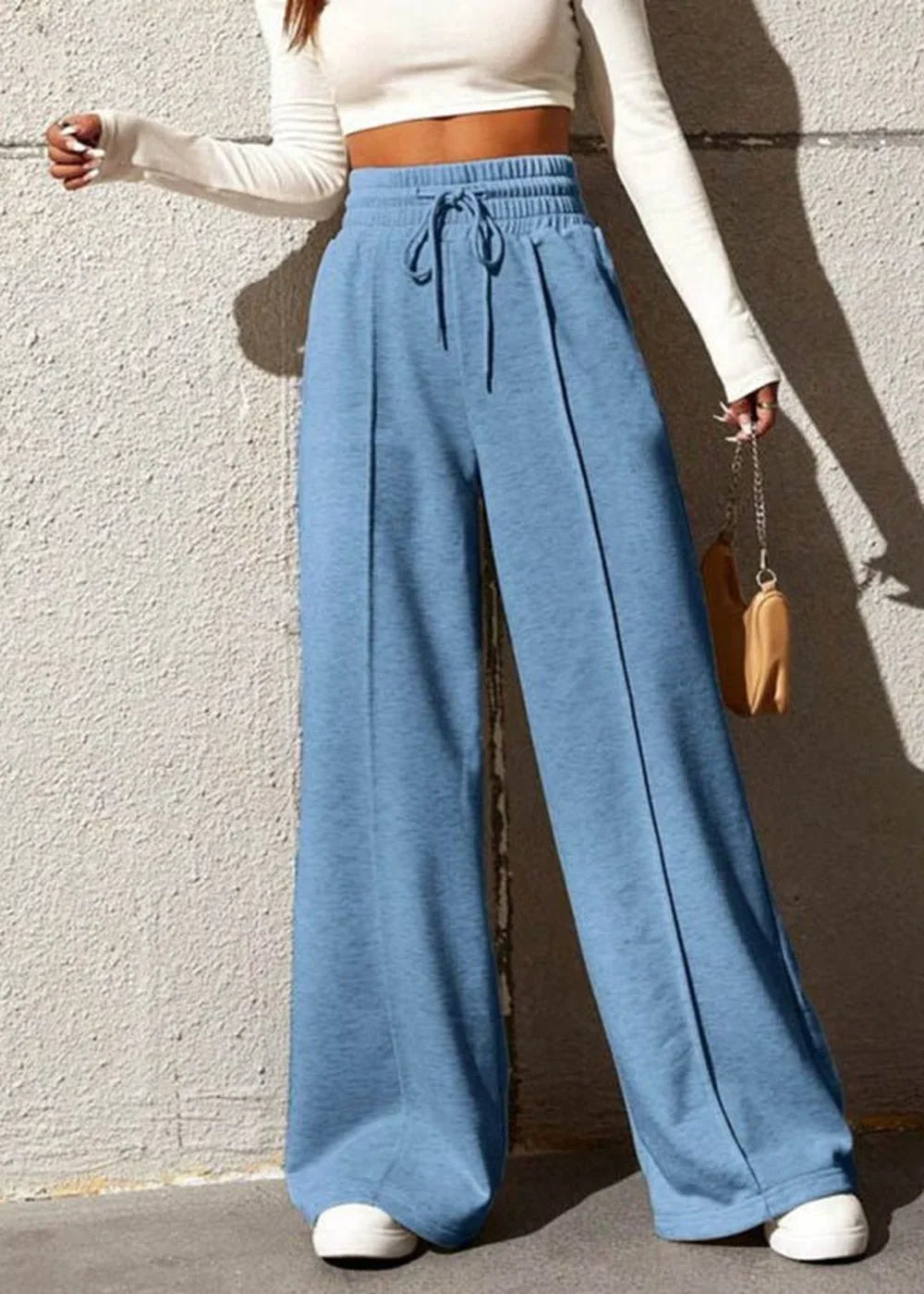 Light blue wide-leg sweatpants with drawstring waist and front seam detail on model.