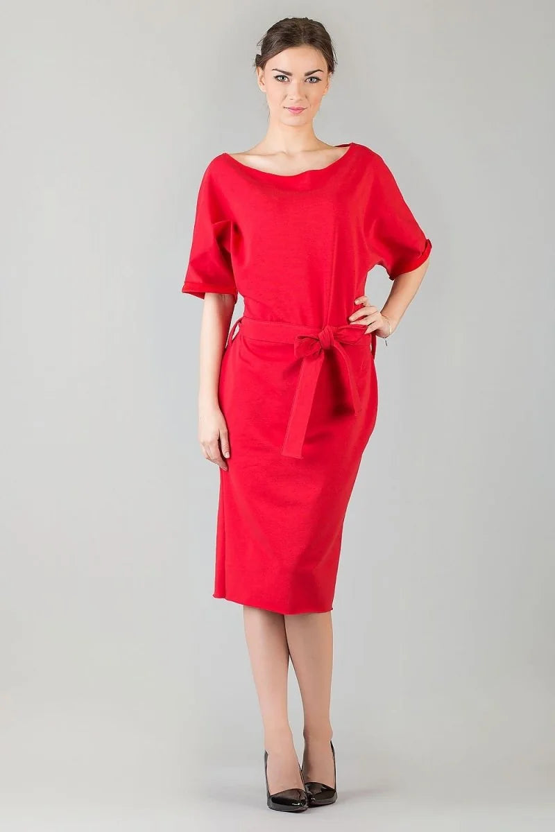 Full length shot of a woman in a relaxed fit, red cotton blend day dress with a tie waist and black heels.