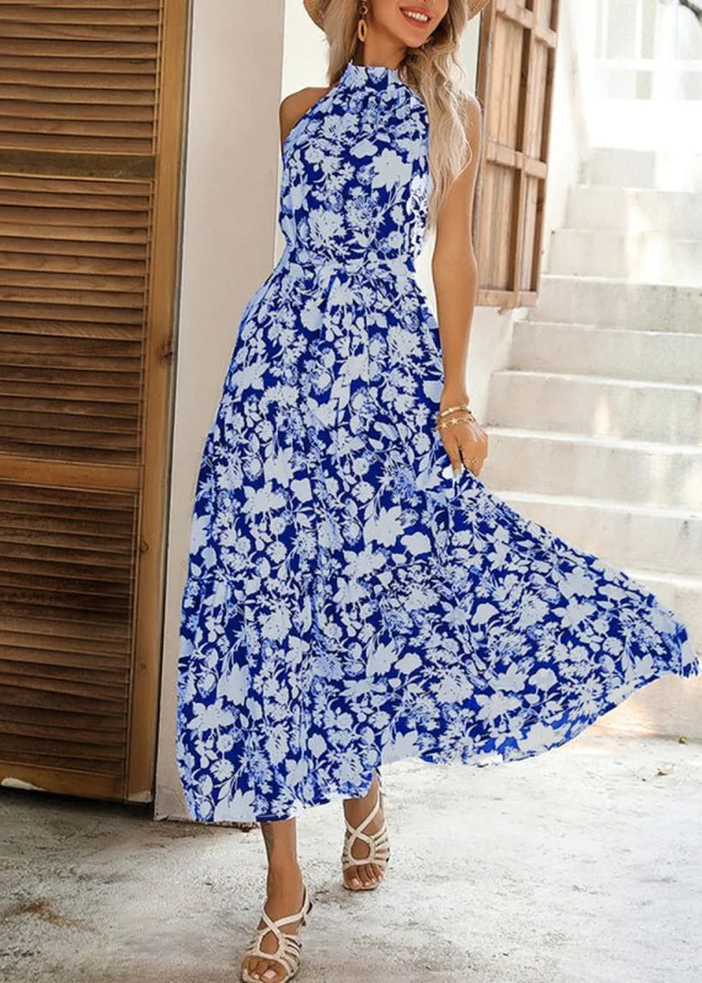 Blue and white floral print halter dress with a cinched waist and flowing skirt.