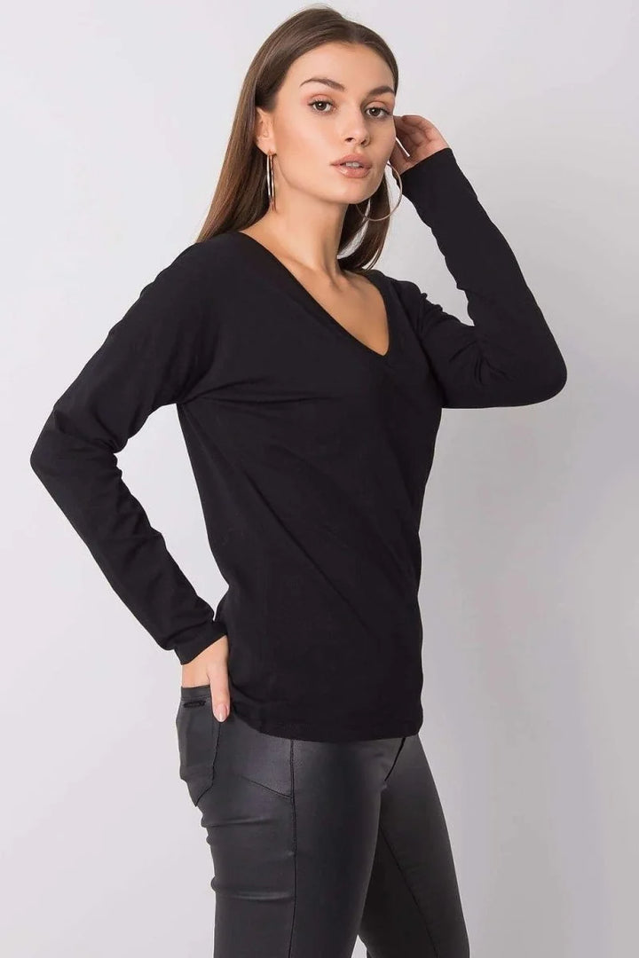 Model in a black, long-sleeved, V-neck top and black leather-look pants.