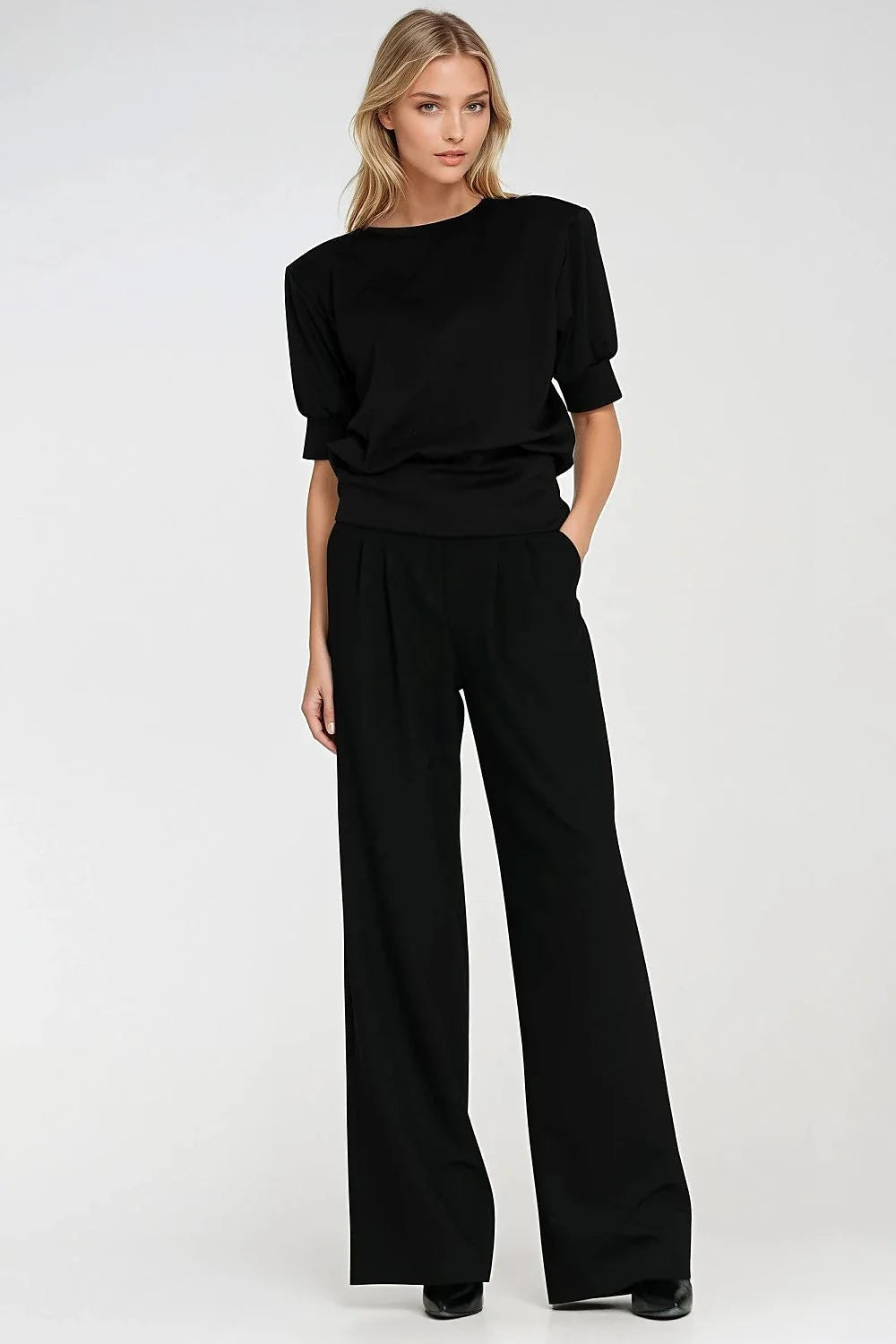 Black oversized fit wide-leg pants with a smooth texture on a model.