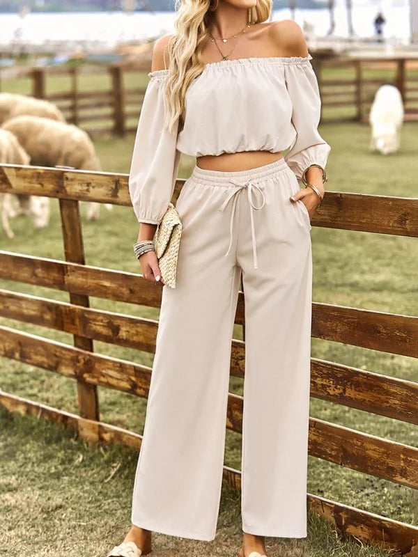 Off-white off-shoulder crop top and wide-leg pants set with drawstring waist, on model.