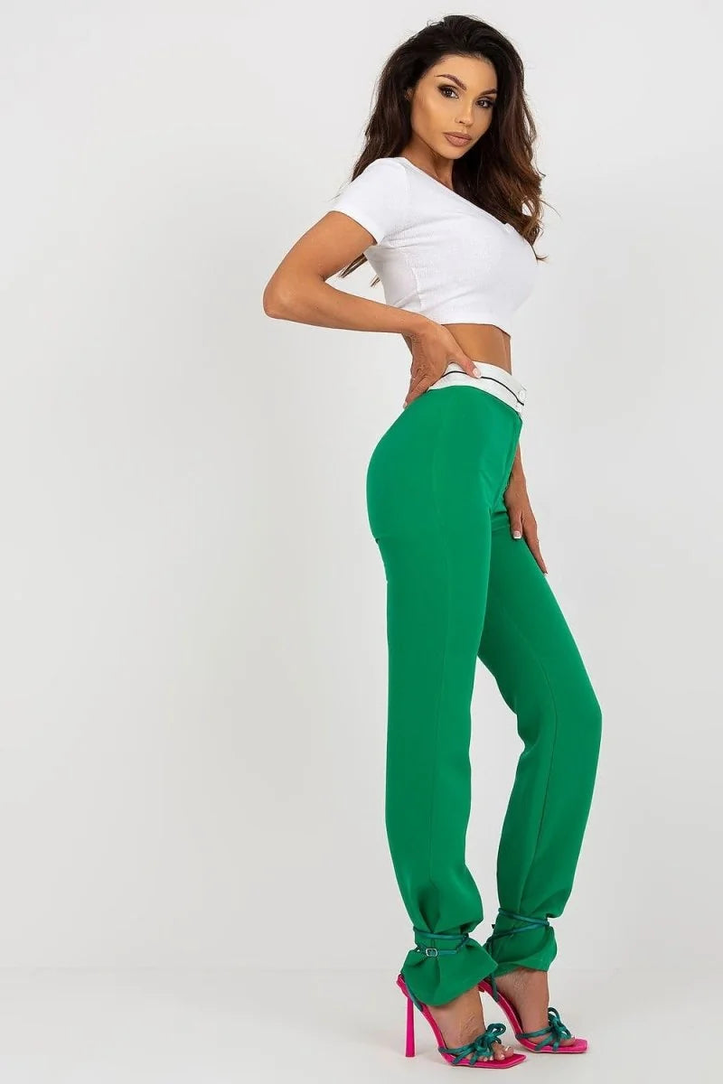 Emerald green wide-leg pants with a white waistband and ruffled ankle cuffs, worn by a model.