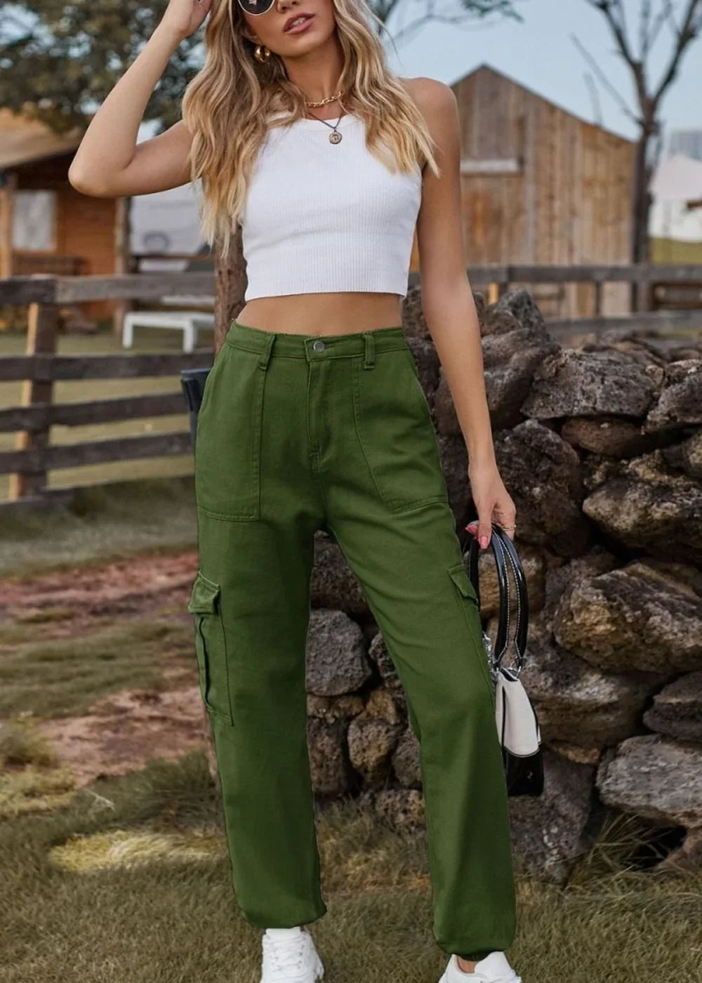 Model wearing olive green cargo pants with a white ribbed crop top.