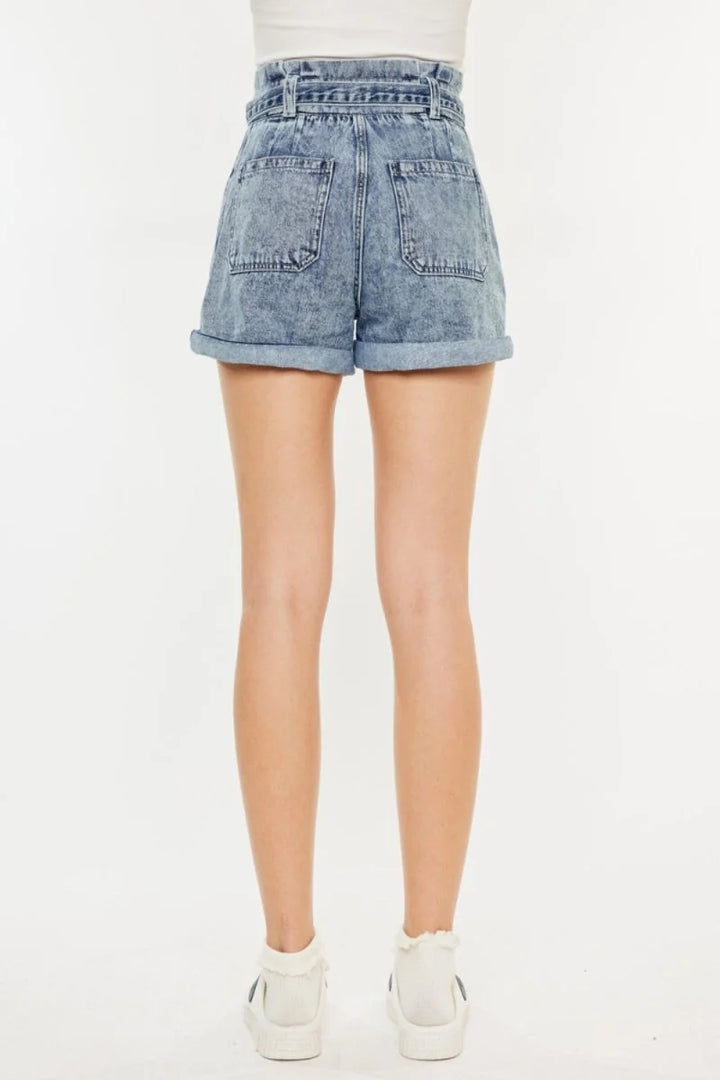 Back view of light blue acid-wash denim shorts with a paperbag waist and cuffed hems.
