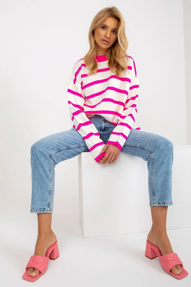 White and hot pink striped relaxed fit sweater with a crew neck, on a model wearing light wash jeans and pink heeled mules.